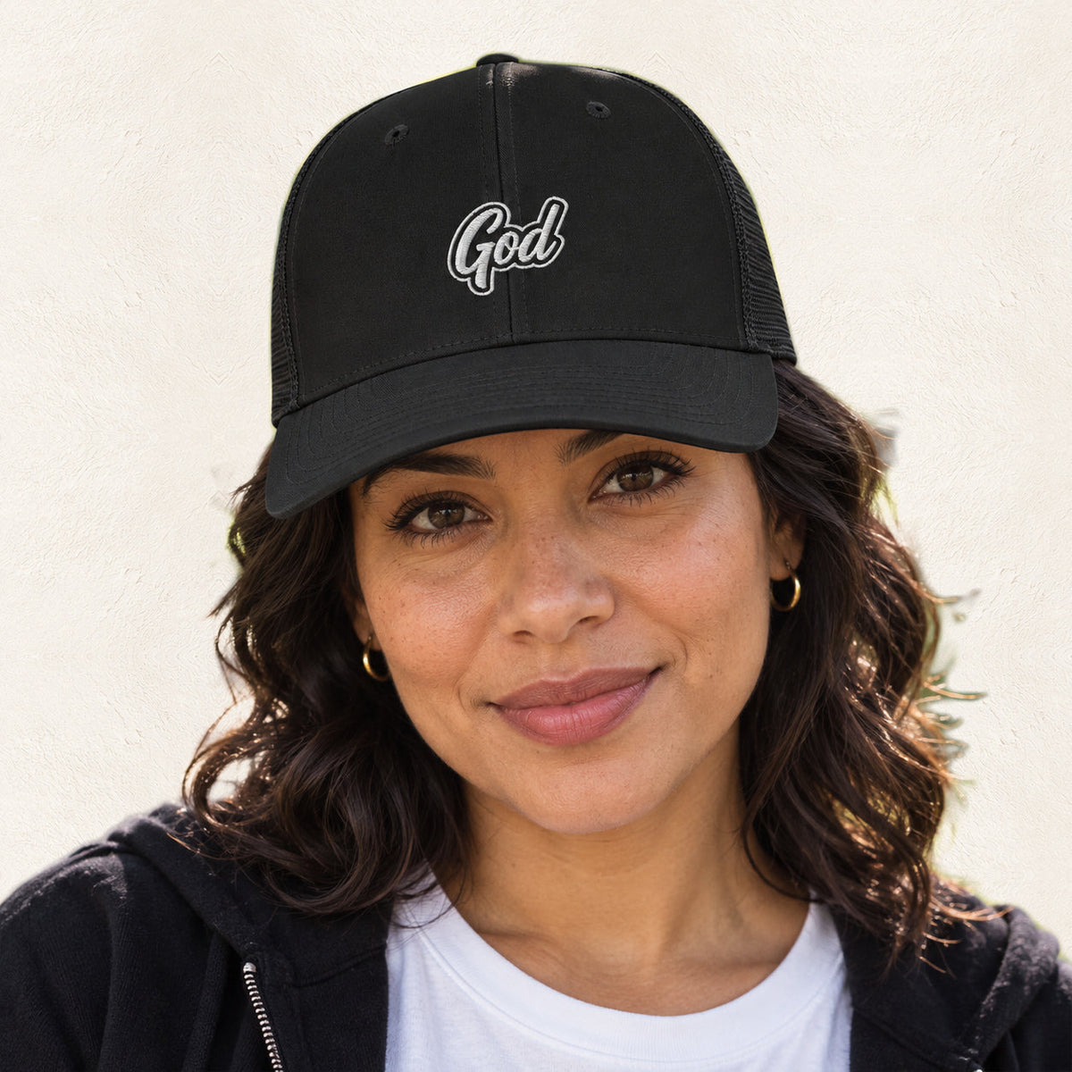 God Embroidered Trucker Hat — original product and design — warm ivory background