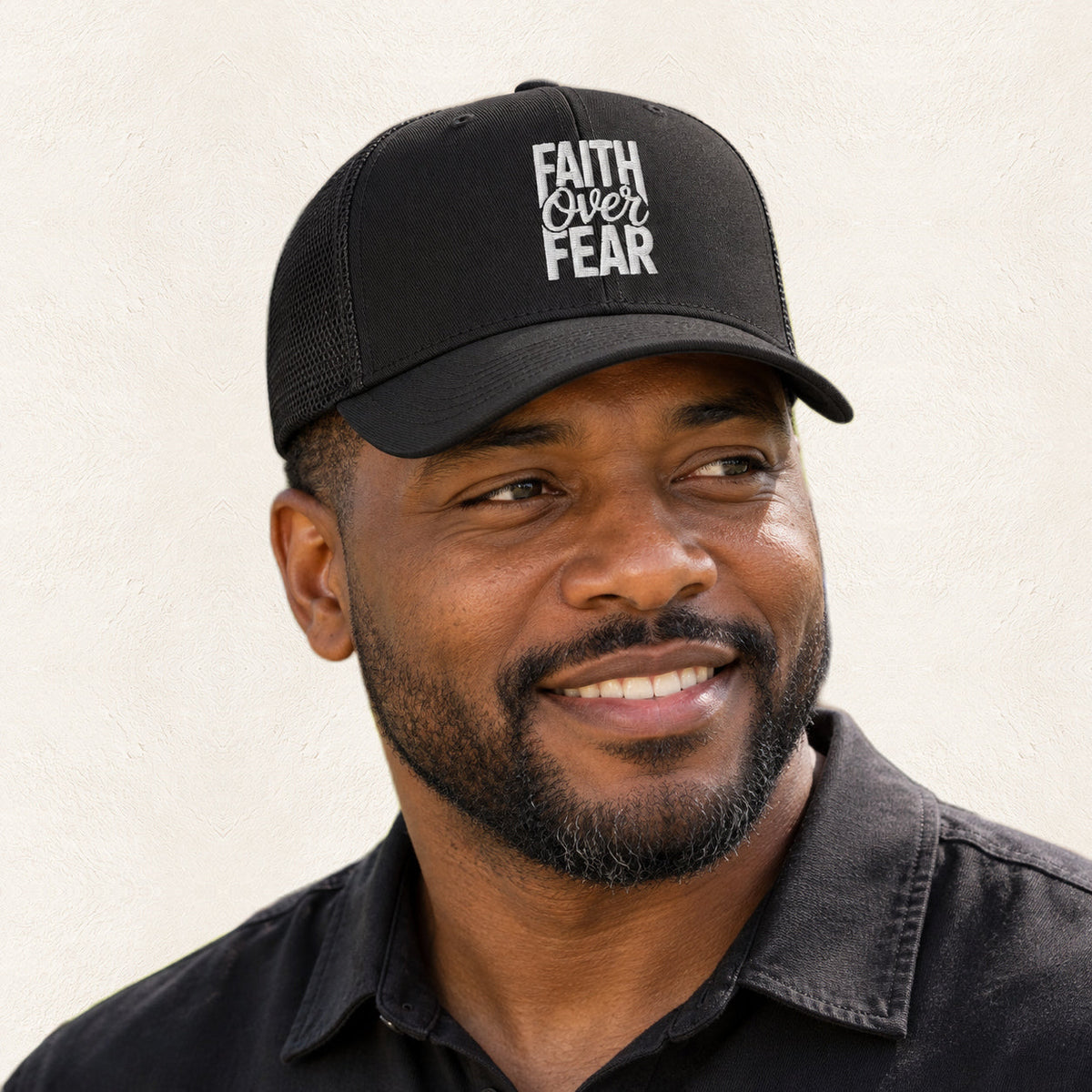 Faith Over Fear Black Embroidered Trucker Hat — original product and design — warm ivory background